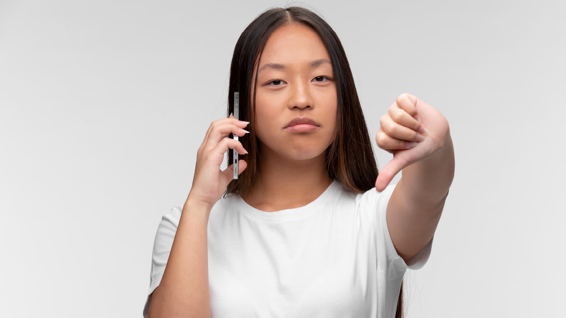 dnc-registry-noncompliance-warning-singapore Woman on a phone call giving a thumbs down, representing the consequences of ignoring Singapore's Do Not Call Registry rules